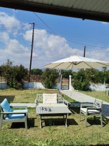 een tafel en twee stoelen en een paraplu bij Green Vila in Sozopoli