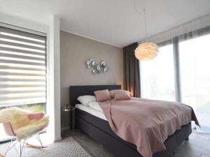 a bedroom with a large bed and a large window at Pleasant villa in Harderwijk with fenced garden in Zeewolde
