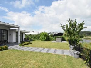 a garden with a lawn and a house at Pleasant villa in Harderwijk with fenced garden in Zeewolde