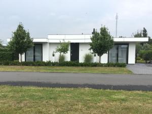 a white building on the side of a road at Pleasant villa in Harderwijk with fenced garden in Zeewolde