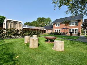 een park met een bank en drie boomstammen in het gras bij Luxury Villa in Megchelen with Sauna in Megchelen