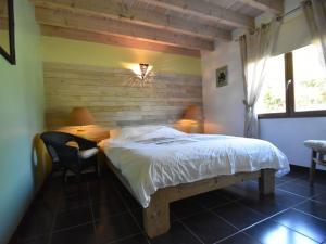 Schlafzimmer mit einem Bett, einem Schreibtisch und einem Fenster in der Unterkunft Villa with heated pool and hot tub in Vélieux