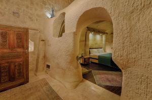 a bedroom with a bed in a stone wall at Taru Cave Suites in Urgup