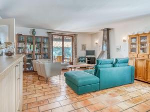 sala de estar con sofá azul y mesa en Hillside villa on private grounds with views, en Prades-sur-Vernazobre