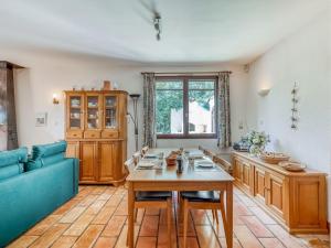 sala de estar con mesa y sofá azul en Hillside villa on private grounds with views, en Prades-sur-Vernazobre