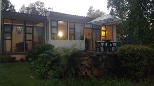 a small house with a table and an umbrella at Sabi falls accommodation in Sabie