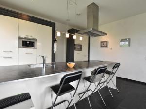 una cocina con una encimera con sillas alrededor en Villa with sauna near the Salland Ridge, en Luttenberg