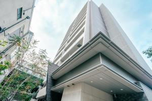 een hoog wit gebouw met een piramidevorm bij 谷町君 HOTEL 日本橋47 in Osaka
