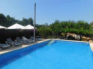 a large swimming pool with chairs and umbrellas at Belvilla by OYO Aubergine in San Miguel de Balansat