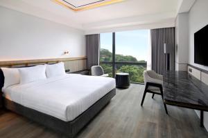 a hotel room with a bed and a desk at Hotel Aruss Semarang in Semarang