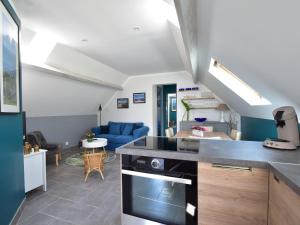 een keuken en een woonkamer met een blauwe bank bij Superb holiday home near the beach in Quinéville