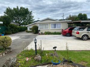 een huis met een auto op een oprit bij Green garden home in Whangarei