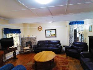 a living room with a couch and a table at BillsBest Whaleback Cottage in Ramsgate
