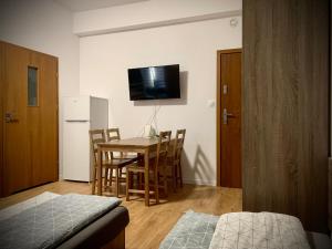 Habitación con mesa, sillas y TV. en Hostel Sportowa en Płońsk