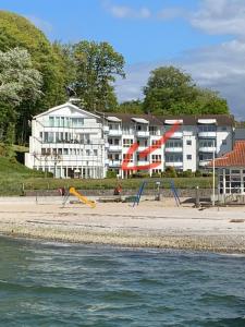 a building on the beach next to the water at Villa Mare Meerblick in Glücksburg