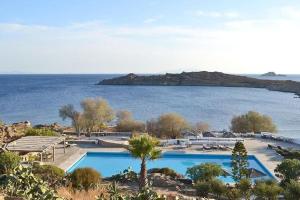 a resort with two pools and a body of water at Opis studio in Ornos