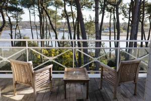 2 Stühle und ein Tisch auf einem Balkon mit Aussicht in der Unterkunft Hotel La Villa Bel Ange in Saint-Philibert