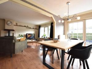 uma sala de jantar e sala de estar com mesa e cadeiras em Modern Holiday Home in Kaatsheuvel with bubble bath em Kaatsheuvel