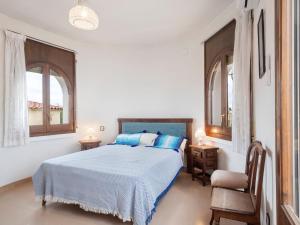 um quarto branco com uma cama e 2 janelas em Belvilla by OYO Amfora Cugat em Sant Pere Pescador