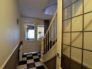 a hallway with a door and a checkered floor at Quietly located mansion near the centre of The Hague in The Hague