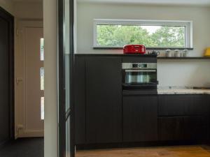 a kitchen with a stove and a window at Holiday home on island Texel with sauna in Westermient