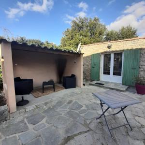 un patio con tavolo e un edificio di mini villa studio que du bonheur a Calenzana