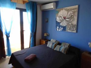 1 dormitorio azul con 1 cama con pared azul en Anju Villas Cotillo 1 Apartment, en Cotillo