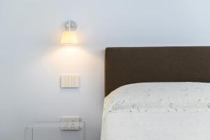 sypialnia z łóżkiem i 2 lampkami na ścianie w obiekcie Corso Umberto 58 w mieście Neapol