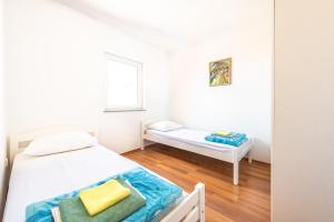 ein kleines Schlafzimmer mit 2 Betten und einem Fenster in der Unterkunft Apartment Damir in Novalja