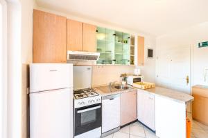 eine Küche mit einem weißen Kühlschrank und einer Spüle in der Unterkunft Apartment Damir in Novalja