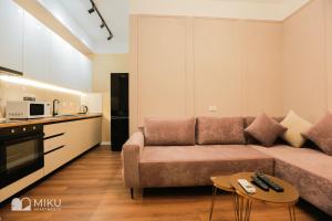 a living room with a couch and a kitchen at Miku Apartment - Perfect 1Bedroom At Komuna e Parisit in Tirana