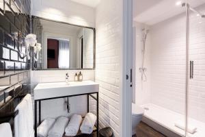 a white bathroom with a sink and a mirror at Fly Rooms Madrid Airport in Madrid +120 photos