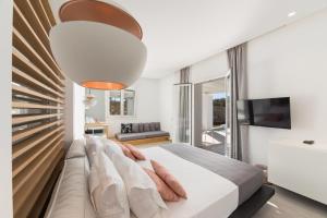 a bedroom with a large bed with a couch at Paros Agnanti Resort & Spa in Parikia