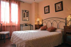 a bedroom with a bed with a white bedspread at Casa Rural El Carrascal in Casarejos