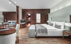 ein Hotelzimmer mit einem Bett und einem Wohnzimmer in der Unterkunft Lebenberg Schlosshotel-Kitzbühel in Kitzbühel