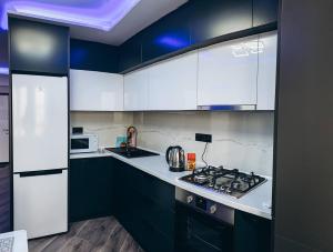a kitchen with white cabinets and a stove top oven at Charming Apartment in Chişinău +11 photos