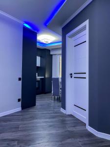 an office with a hallway with a door and blue lights at Charming Apartment in Chişinău