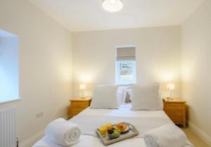a bedroom with a bed with a tray of fruit on it at The Lodge in Coltishall