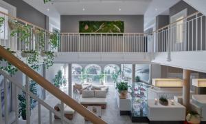 uma sala de estar com mobiliário e plantas brancas em Lebenberg Schlosshotel-Kitzbühel em Kitzbühel