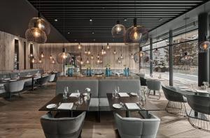 restauracja ze stołami i krzesłami oraz barem w obiekcie Lebenberg Schlosshotel-Kitzbühel w mieście Kitzbühel