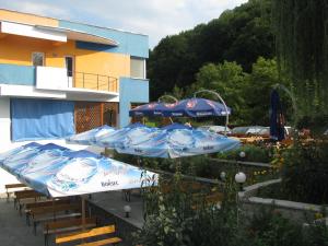 a group of blue umbrellas sitting on a patio at Motel Blue River Calimanesti in Călimăneşti