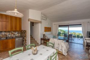 a kitchen and living room with a view of the ocean at Villa Turchese - Key to Villas in Costa Paradiso
