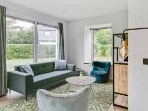 sala de estar con sofá verde y 2 sillas en Bungalow in Texel near National Park Dunes, en Westermient