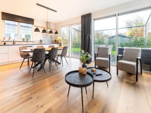 een keuken en een woonkamer met een tafel en stoelen bij Pretty Holiday Home in De Koog Texel with Garden in Westermient