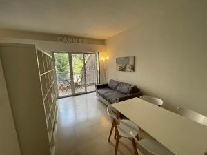 un soggiorno con tavolo, sedie e divano di Appartements Villa Rimbaud by Connexion a Cannes