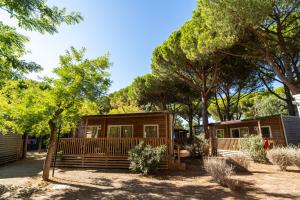 a cabin in the woods with trees in the background at Club del Sole Orbetello Family Collection in Orbetello