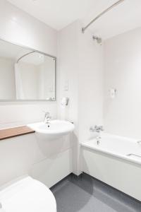 a white bathroom with a sink and a tub at Kings Highway, Derby by Marston's Inns in Derby