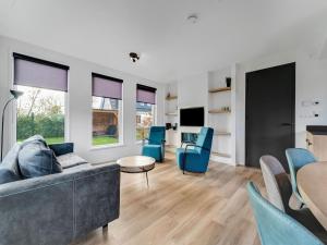 een woonkamer met een bank, stoelen en een tafel bij Appealing Holiday Home in De Koog Texel with Sauna in Westermient