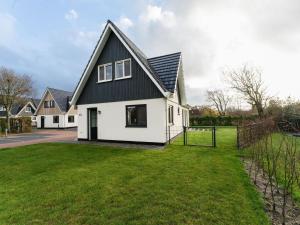 a white house with a black roof and a yard at Wonderful Holiday Home in De Koog Texel with Terrace in Westermient