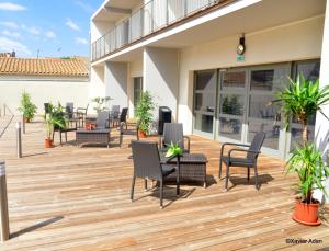 a deck with chairs and tables on a building at Douce France in Cuxac-dʼAude